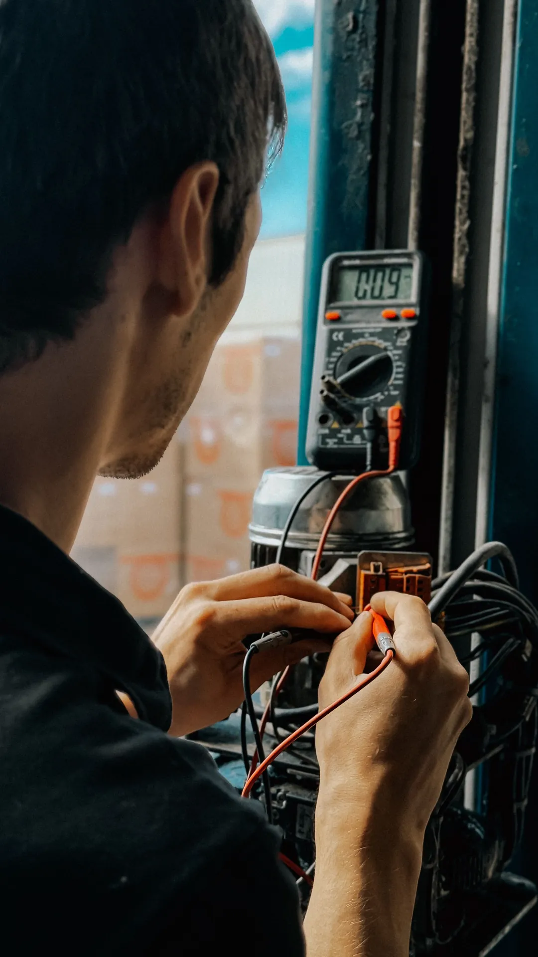 Technician taking readings with a multimeter in a workshop