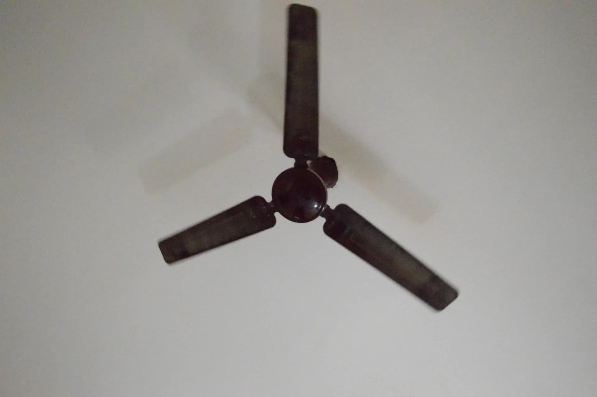 Three-blade ceiling fan mounted on a ceiling