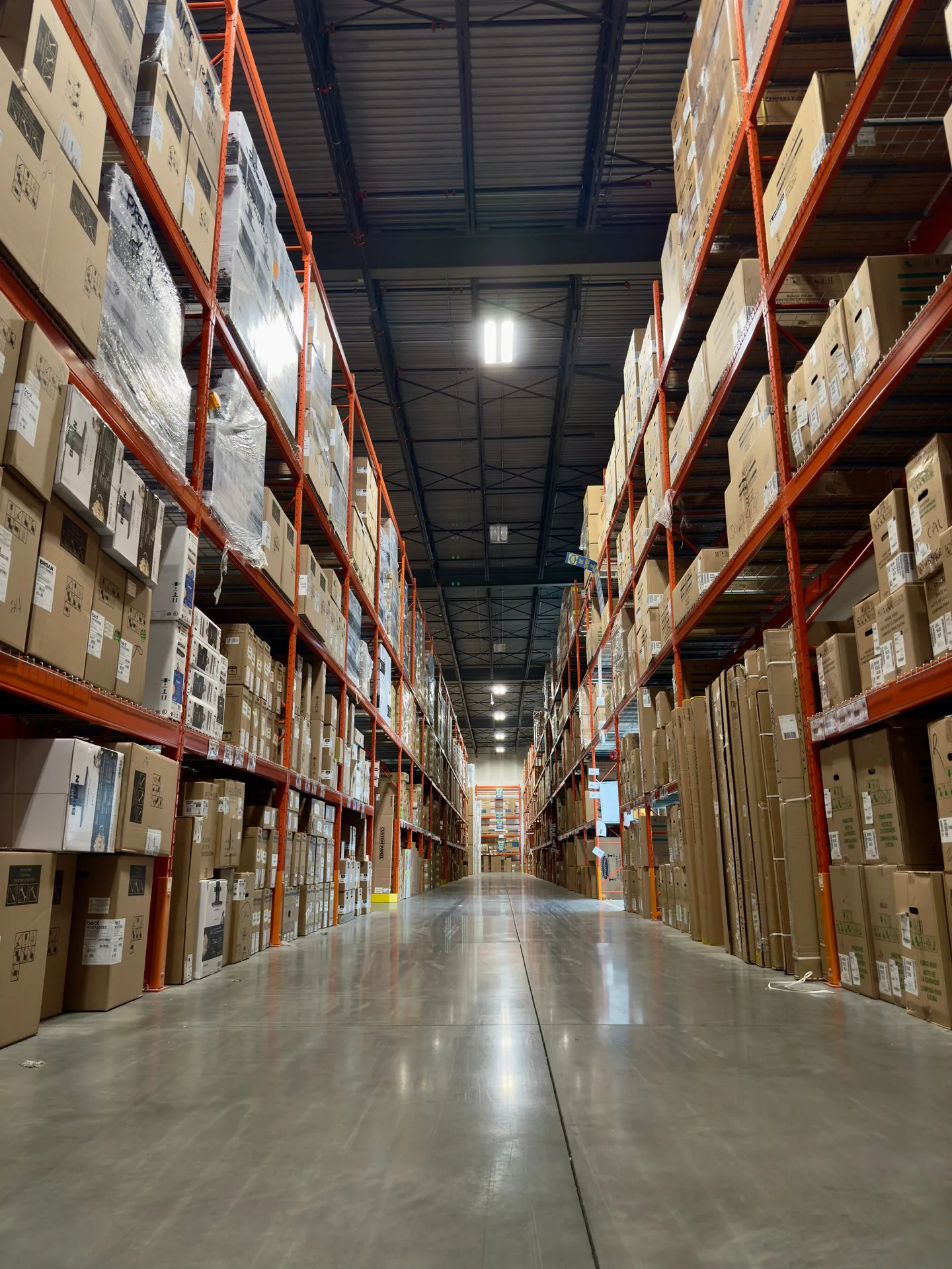 Aisle of a warehouse stocked with product on tall racking